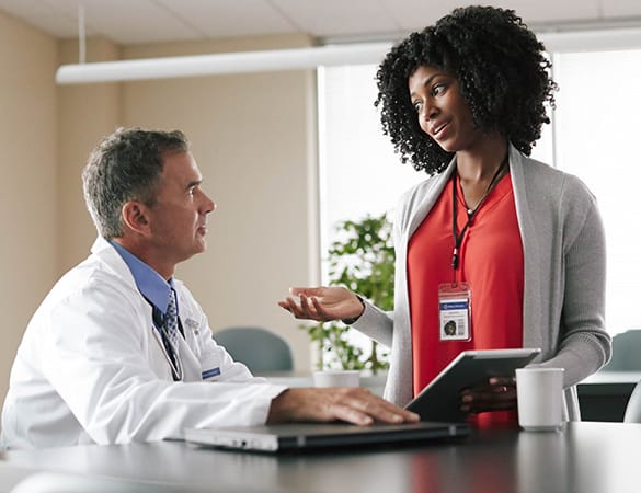 Photo of a doctor having a conversation with an administrator.