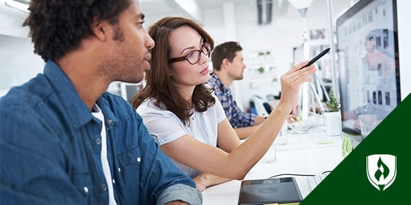 photo of an art director pointing out something on a monitor to a coworker