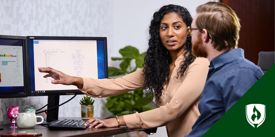 woman working at computer with man