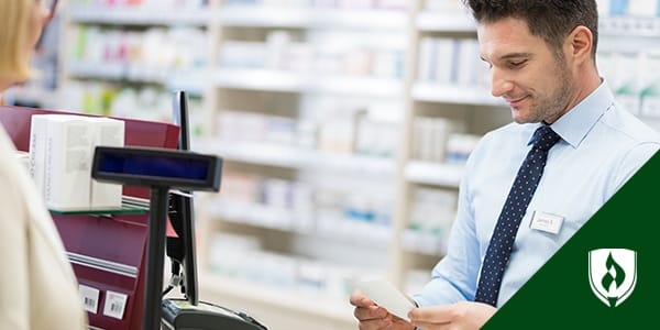 male pharmacy technician helping customer at checkout