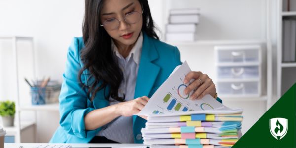 A bookkeeper sorts through tabbed documents