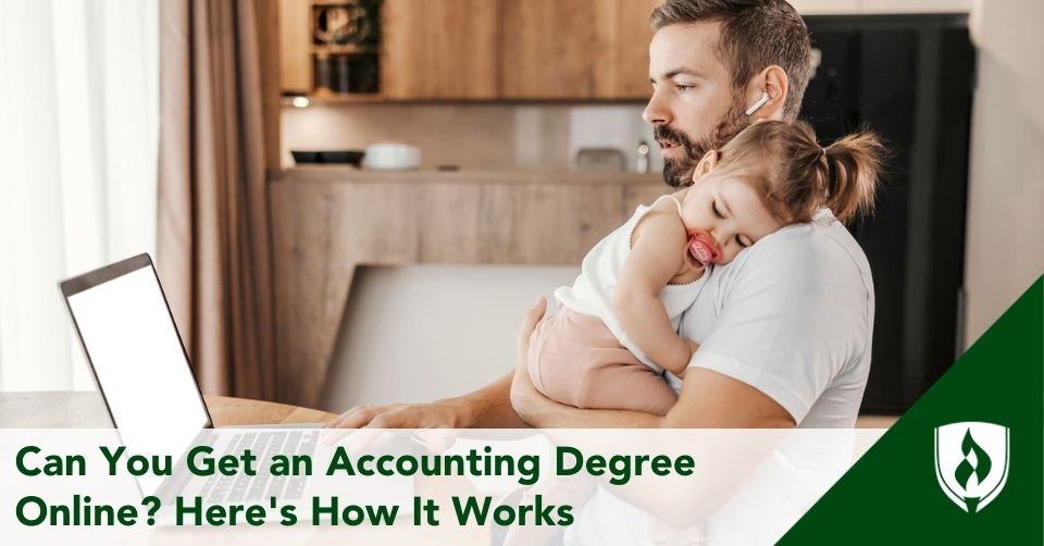 A father holds his baby while working through an online accounting program at home