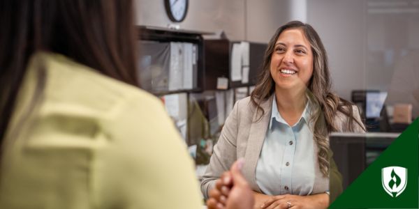 A bank teller greets a customer
