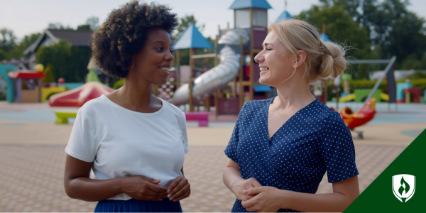 An ECE director talks with a teacher near a playground