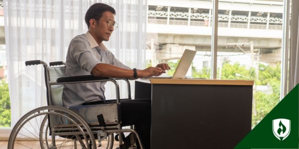 A Medical administrator sits at his desk working on a computer