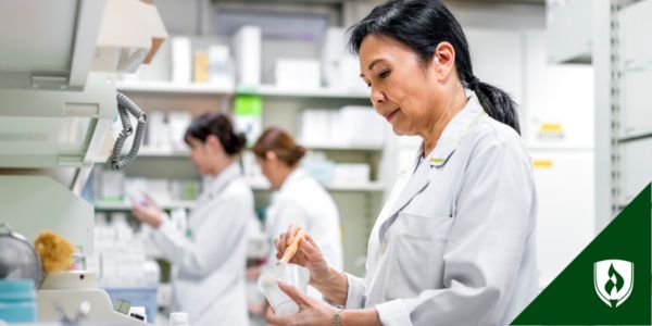 A pharmacists and two pharm techs work in the back of the pharmacy