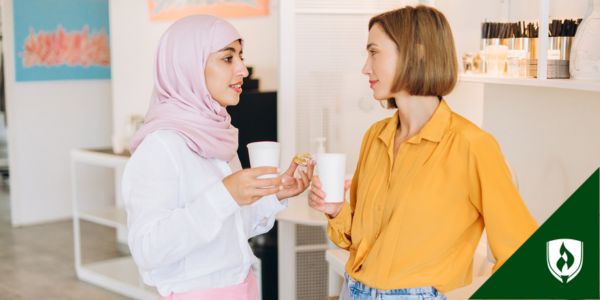 A social worker and social services assistant talk in their office