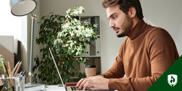 Man typing on laptop sitting at desk