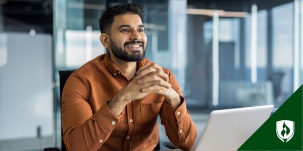 A paralegal sits at his desk smiling and pursuing certification