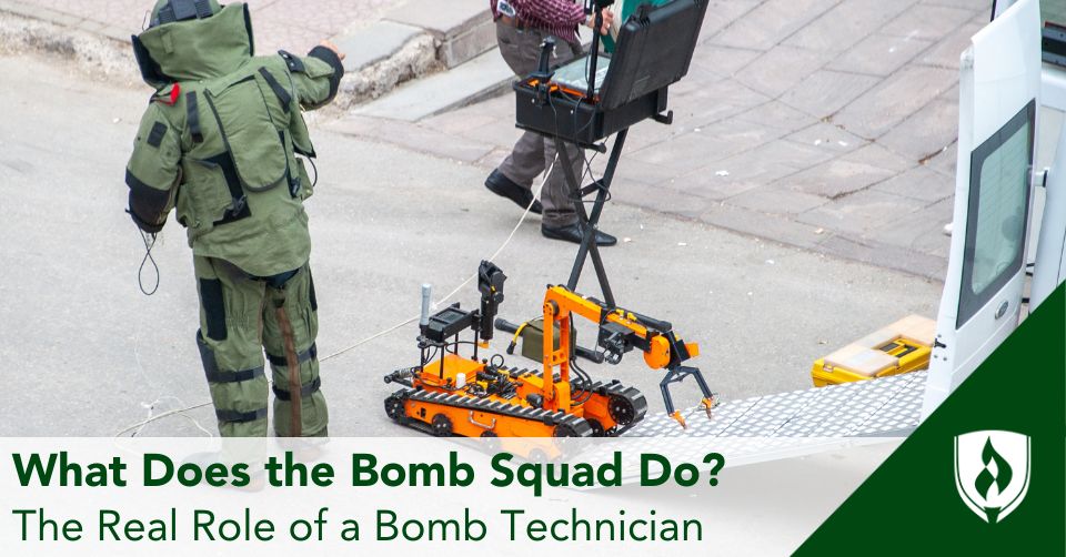 A bomb technician in full protective gear works with a bomb robot