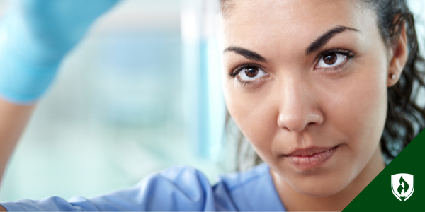 A research nurse stares intently at a test tube