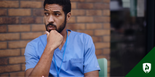 An LPN nurse sits outside his care facility, considering his options