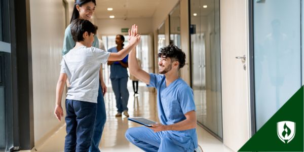 An FNP high fives a child outside the examination room