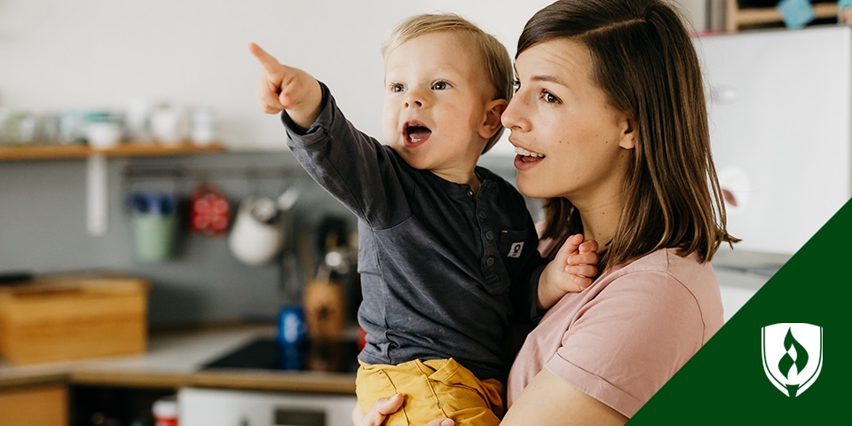 photo of a mom with a toddler pointing at something out of frame