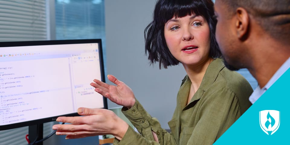 woman talking to man at the computer