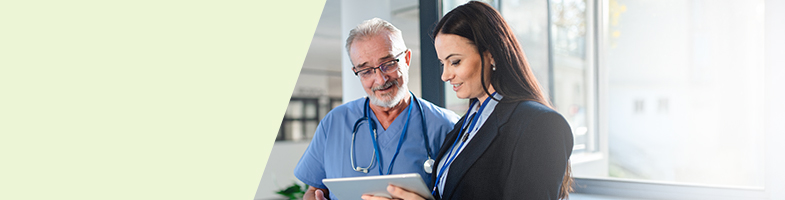 Healthcare Manager reviewing digital records with healthcare worker