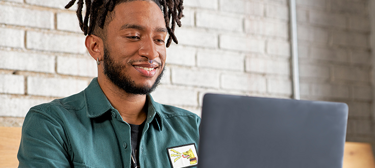 Male graphic design student on laptop tile image