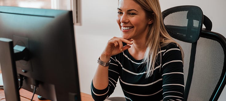 alt="Female smiling at computer MBC 1"