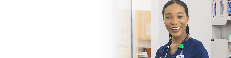 smiling female nurse with stethoscope in medical hallway 