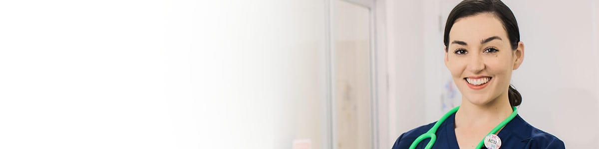 smiling female nurse wearing stethoscope in medical hallway