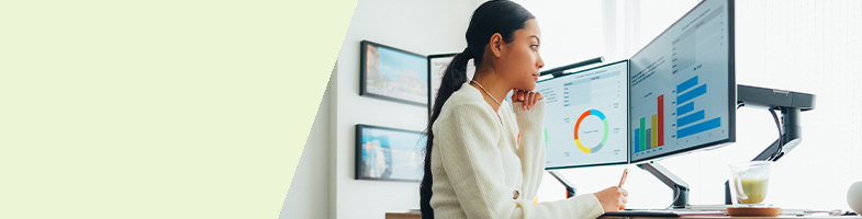 Data Analytics professional sitting at desk viewing data charts on screen